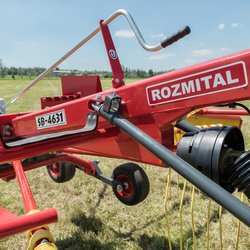 Pohled na rám stroje s tyčí pro ovládání výšky hrabic a nosníkem hrabic při transportu stroje